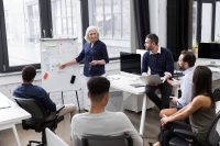 Mature business woman making a presentation for her colleagues at whiteboard